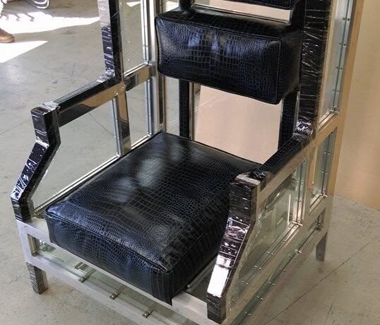 Fabricated Aluminium framed armchair with black leather upholstery