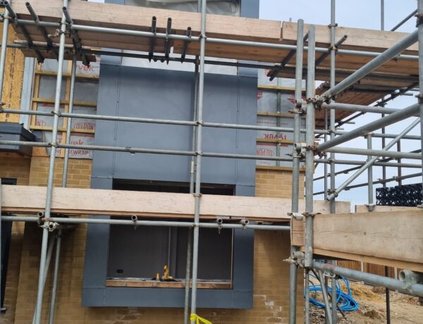 Aluminum cladding installation on a scaffolded building site