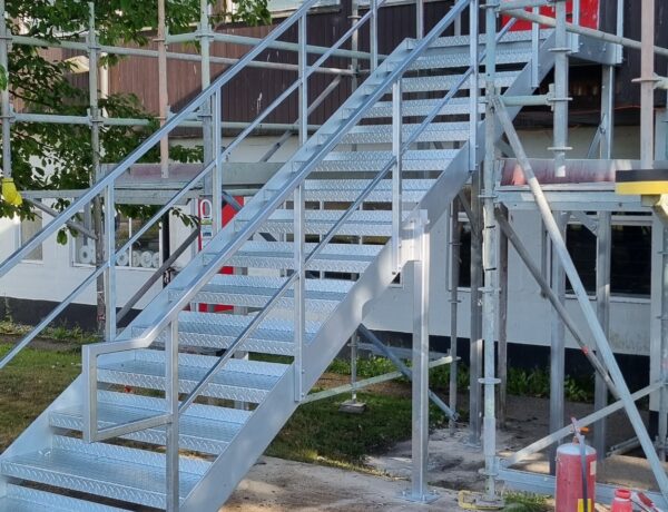 Galvanised steel staircase being installed on a scaffolded site by SAMS Fabrications