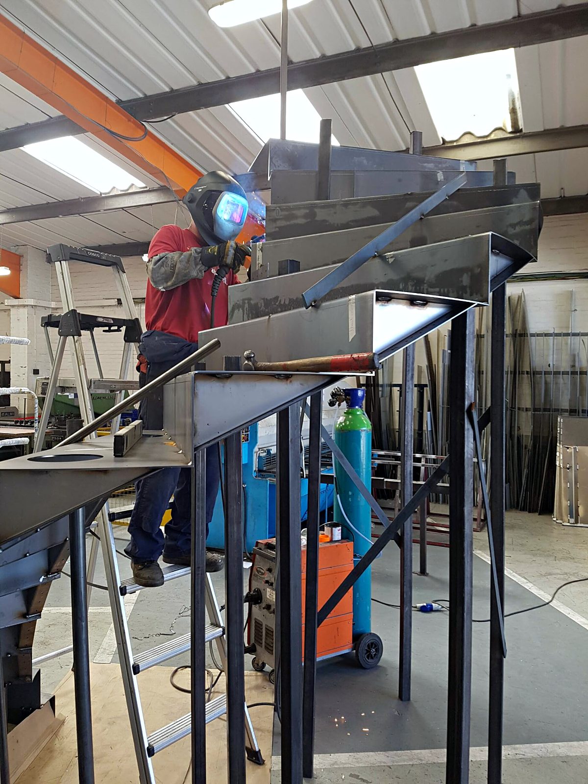 MIG welding a steel fabrication with sparks