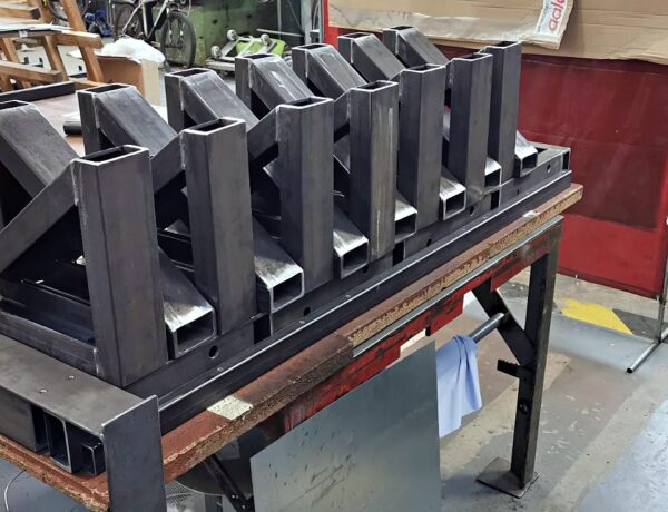 Row of welded steel V-supports on a fabrication bench