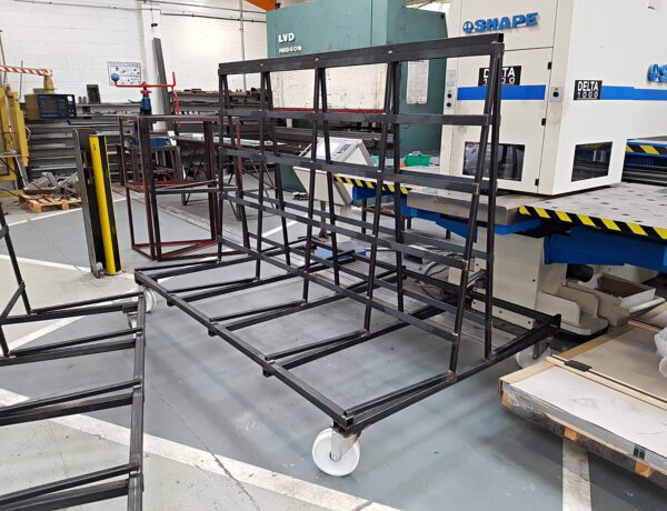 Black steel racks beside the CNC press brake in our workshop